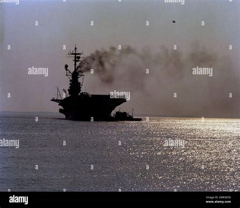 A Silhouetted Bow View Of The Auxiliary Aircraft Landing Training Ship Uss Lexington Avt 16 Being Assisted By A Tug Country Unknown Stock Photo Alamy